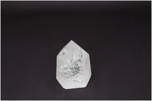Lemurian Quartz Obelisk on dark background, known for clarity and healing properties; ethically sourced and naturally formed crystal.