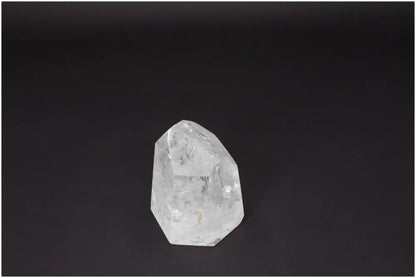 Clear Lemurian Quartz Obelisk on dark background for healing and balance.