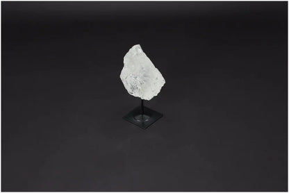 Lemurian Quartz on metal stand against dark background, known for amplifying energy and fostering clarity and personal growth.
