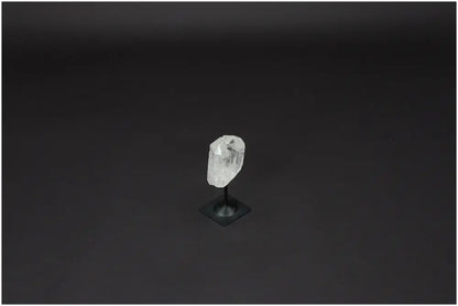 Lemurian Quartz crystal on a sleek metal stand against a dark background, known for clarity and balance in personal growth.