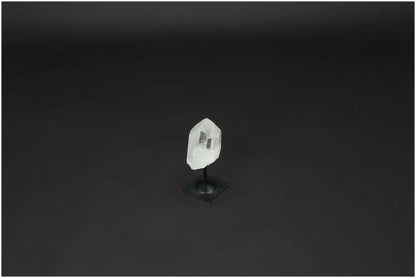 Lemurian Quartz crystal on a metal stand against a dark background, ideal for enhancing clarity and personal growth.