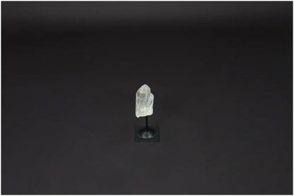 Lemurian Quartz on a metal stand against a dark background, representing clarity and balance in crystal healing.