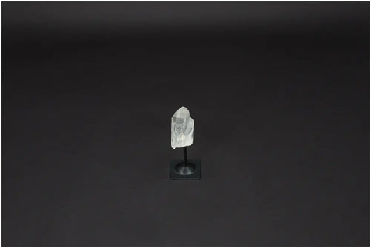 Lemurian Quartz on a metal stand against a dark background, representing clarity and balance in crystal healing.