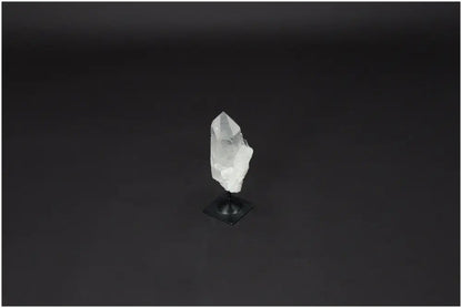 Lemurian Clear Quartz on a metal stand against a dark background, showcasing its natural clarity and healing properties.