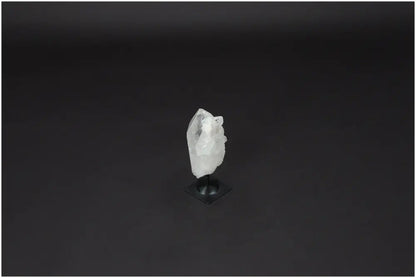 Clear Lemurian Quartz crystal on a metal stand against a black background, ideal for energy amplification and personal growth.