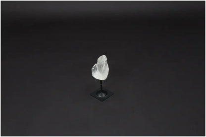 Lemurian Quartz on a metal stand against a dark background, showcasing its clear crystal structure and purifying qualities.