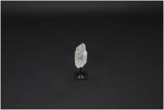 Lemurian Quartz on a metal stand, showcasing its clear, powerful purification properties against negative vibrations.