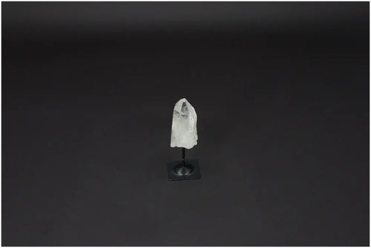 Lemurian Quartz on metal stand with a dark background, ideal for harmonizing body and energy by neutralizing negative vibrations.