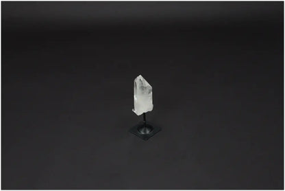 Lemurian Quartz crystal on a sleek metal stand, known for purification and harmonizing mind, body, and energy, against black background.