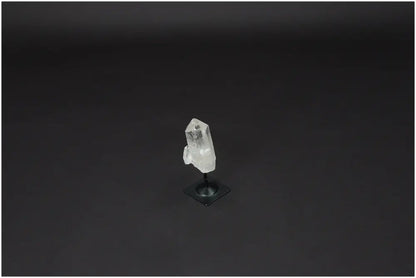 Lemurian Quartz on metal stand, showcasing the clear quartz's purification and harmonizing properties against a dark background.