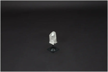 Lemurian Quartz on metal stand against dark background, showcasing its clarity and purifying properties.