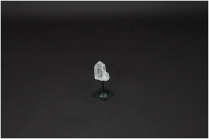 Lemurian Quartz crystal on metal stand against a dark background, known for purifying and harmonizing energy. Perfect for home or office decor.