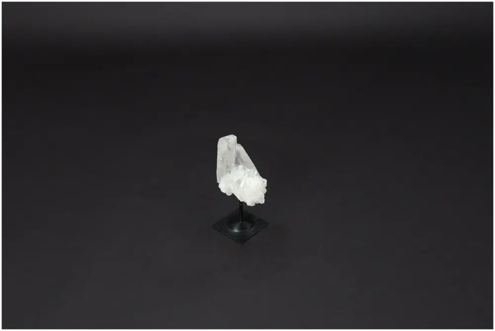 Lemurian Quartz on metal stand against dark background, showcasing its clear, purifying properties and harmonizing energy