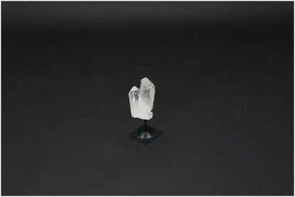 Lemurian Quartz on metal stand, showcasing clear quartz known for energy purification and harmonizing properties against a dark background.