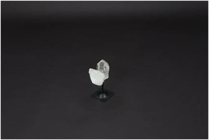 Lemurian Quartz crystal on elegant metal stand against dark background, known for purification and absorbing negative energy.