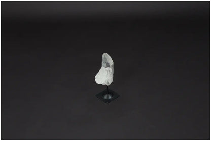 Lemurian Quartz on metal stand against dark background, showcasing its clarity and energy purification properties. Ideal for harmonizing spaces.