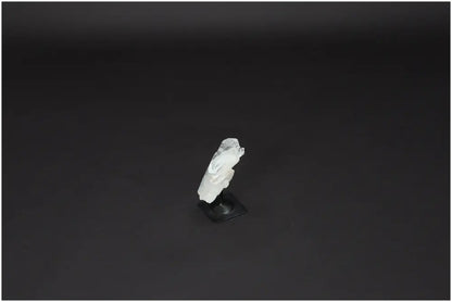 Lemurian Quartz on metal stand, known for purification and neutralizing negative energy, displayed against a dark background.