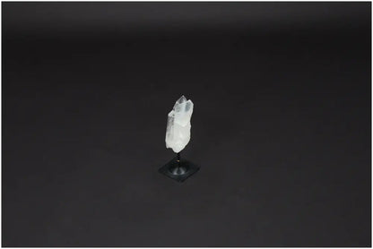 Lemurian quartz crystal on metal stand, used for purification and harmonizing energy, with sleek black background.
