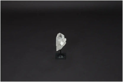 Lemurian Clear Quartz on a metal stand against a dark background, known for purification and neutralizing negative energy.