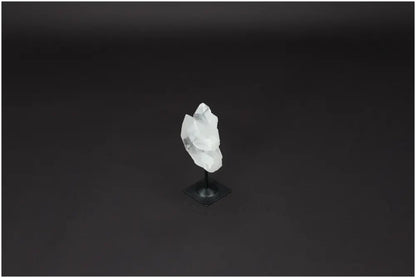 Lemurian Quartz crystal on metal stand against a dark background, known for purification and neutralizing negative vibrations.