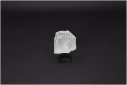 Lemurian quartz crystal on metal stand, ideal for energy purification and neutralizing negative vibrations, against dark background