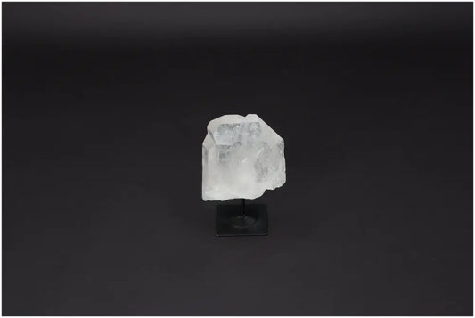 Lemurian quartz crystal on metal stand, ideal for energy purification and neutralizing negative vibrations, against dark background