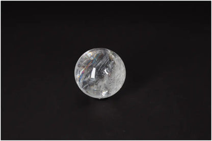 Lemurian Quartz Sphere on black background showcasing clarity and subtle striations, embodying ancient wisdom and high-vibrational energy.