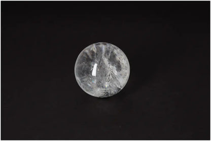 Lemurian Quartz Sphere 6-7 CM displaying radiant clarity and ancient energy on a dark background.