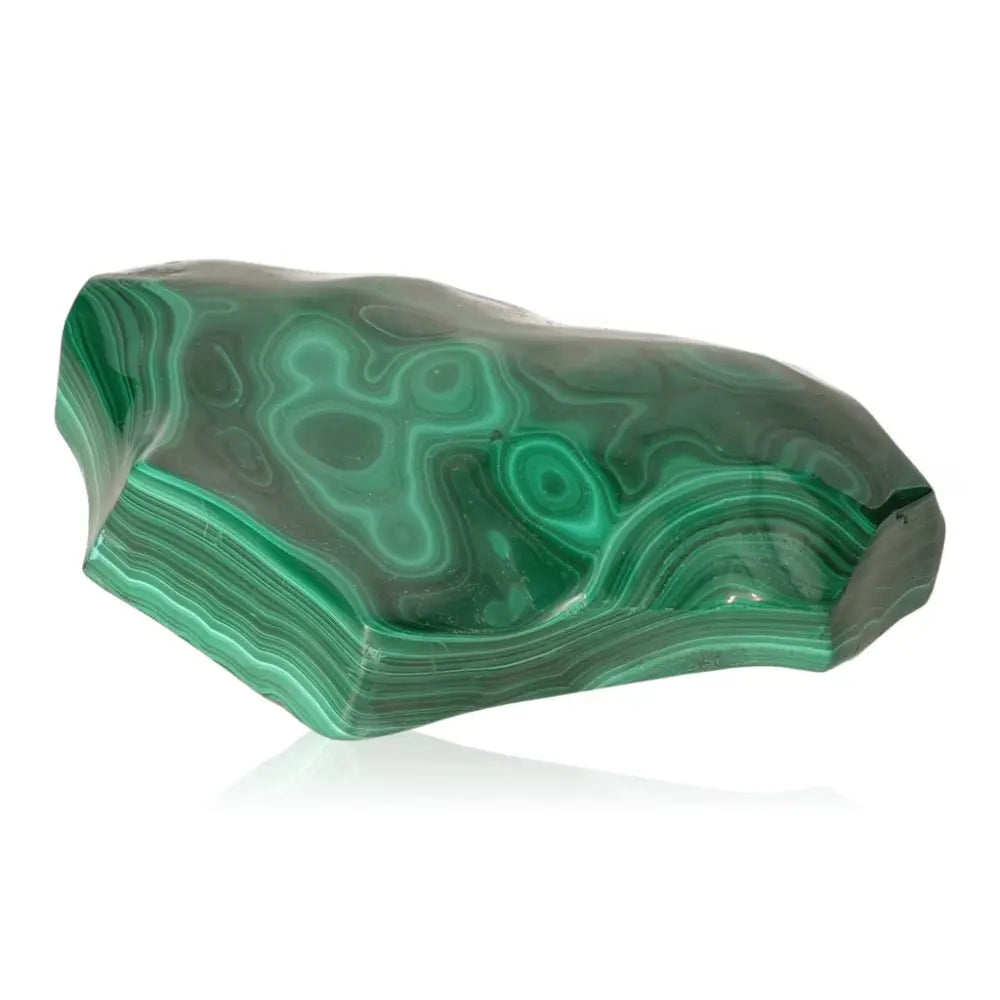 Polished malachite gemstone radiating green hues, embodies nature's tranquility and encourages courage and hope in life's transitions.