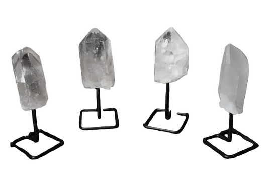 Natural clear quartz points with stands, known for energy amplification and clarity, elegantly displayed against a dark backdrop.