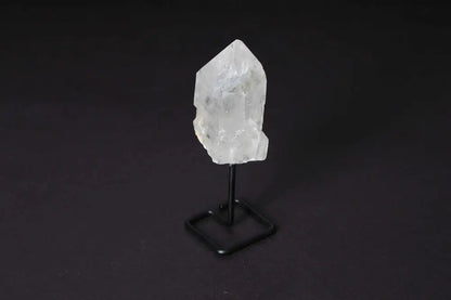 Clear quartz point on modern stand for energy amplification and focus in meditation or manifestation, elegant decor piece.