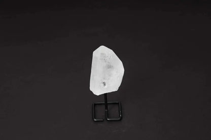 Natural Clear Quartz Point with stand on black background, ideal for amplifying energy and enhancing clarity in meditation and manifestation.