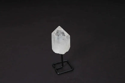 Natural Clear Quartz Point on modern stand for energy amplification and meditation.