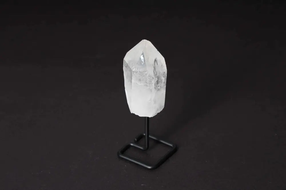 Natural clear quartz point on a stand, ideal for meditation, manifestation, and energy work, amplifying focus and clarity.