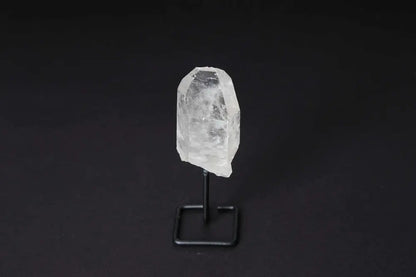 Natural clear quartz point on a stand, perfect for meditation and energy alignment, enhancing clarity and focus in any space.