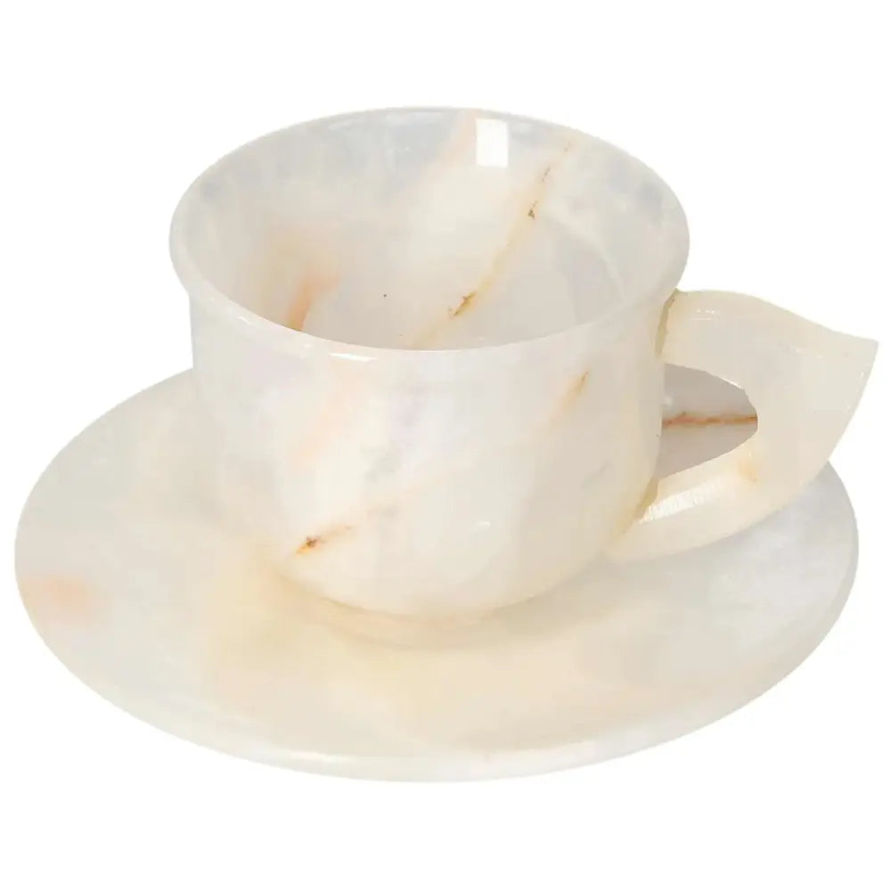 Off-white onyx coffee cup and plate set, showcasing unique patterns and a polished surface that reflects soft light, enhancing elegance.