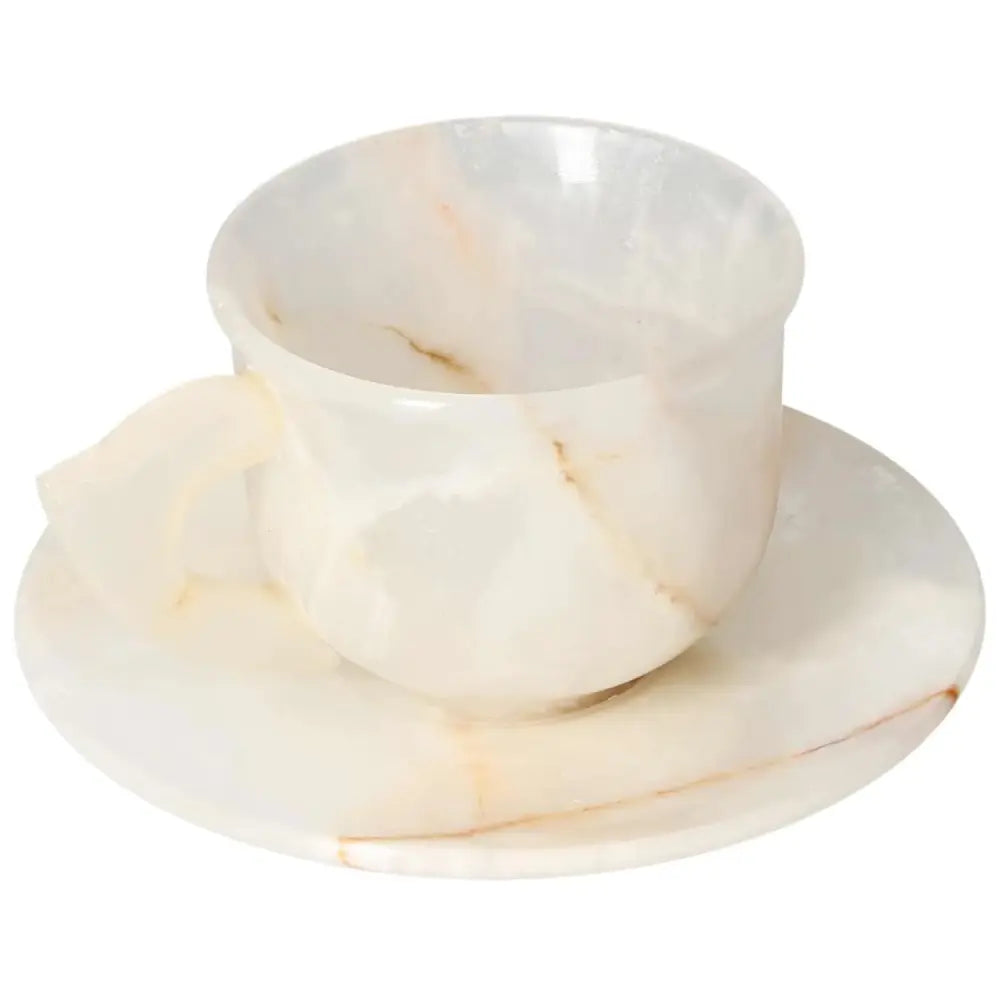 Off-white onyx coffee cup and plate set with smooth polished surface reflecting ambient light, showcasing unique tone variations.