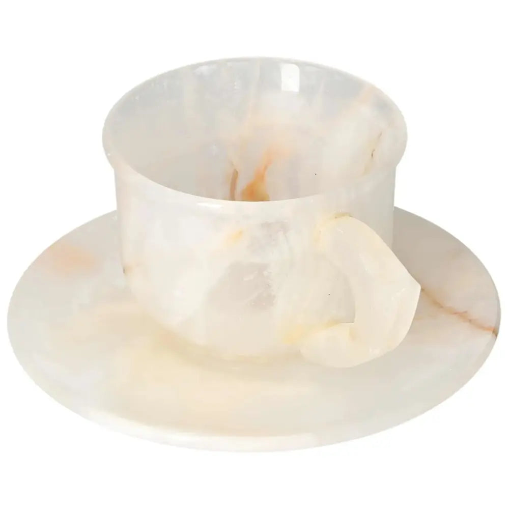 Elegant off-white onyx coffee cup and plate set with unique patterns, showcasing polished surface and natural beauty.