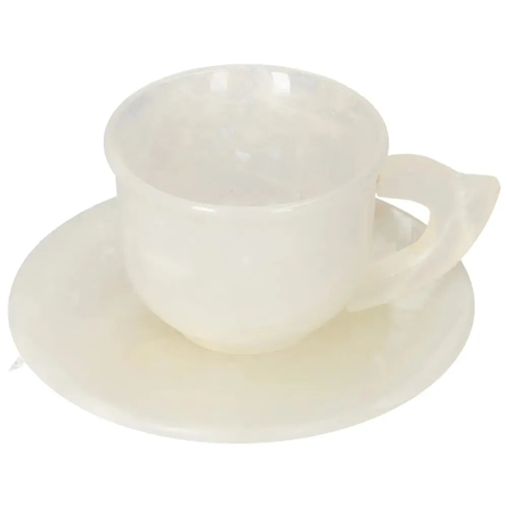 Elegant off-white onyx coffee cup and plate set with smooth surface and unique natural variations, reflecting soft ambient light.