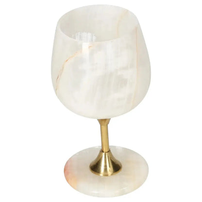 Elegant off-white onyx wine glass with brass stem, showcasing unique veined patterns, perfect for adding sophistication to any occasion.