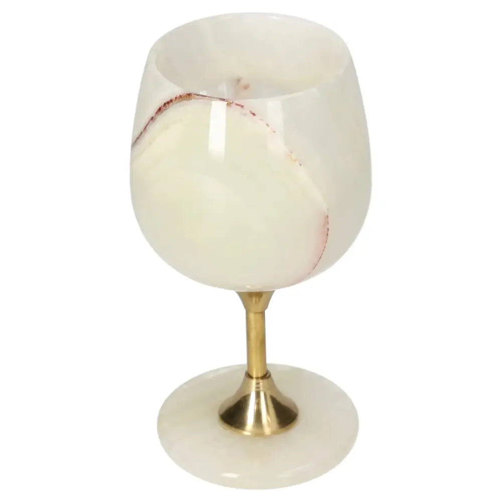 Luxurious onyx wine glass with gold stem, showcasing unique white and red veining, perfect for elegant dining occasions.