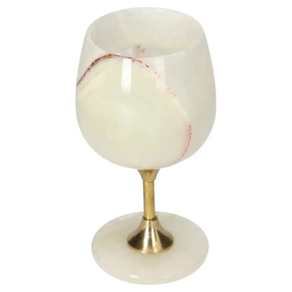 Luxurious onyx wine glass with gold stem, showcasing unique white and red veining, perfect for elegant dining occasions.