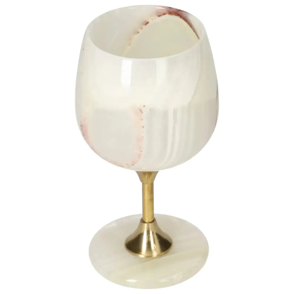 Elegant off-white onyx wine glass with unique veining, polished surface, and gold stem, adding sophistication to fine dining.