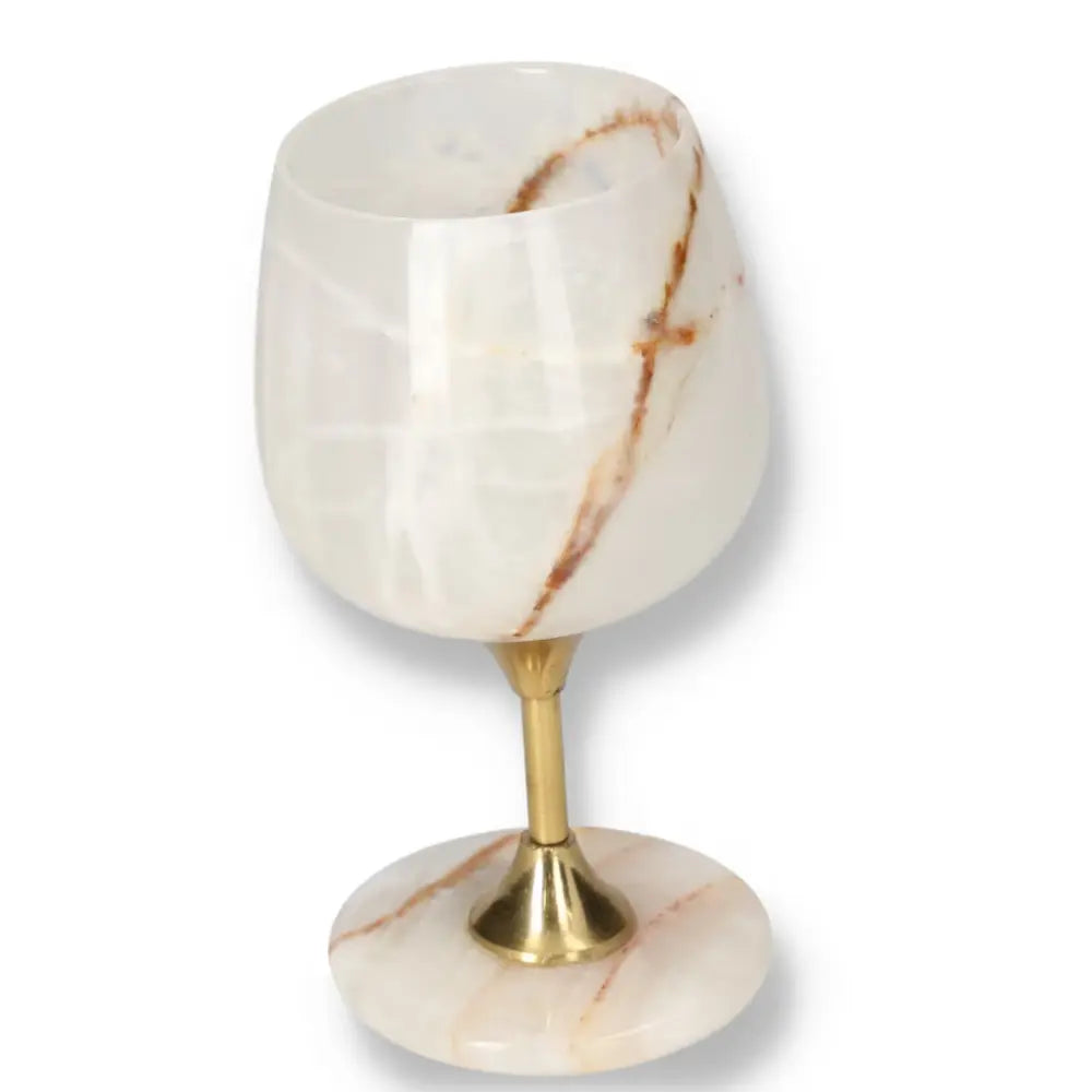 Exquisite onyx wine glass with unique veining, polished surface, and gold stem, exemplifying elegance and natural allure.