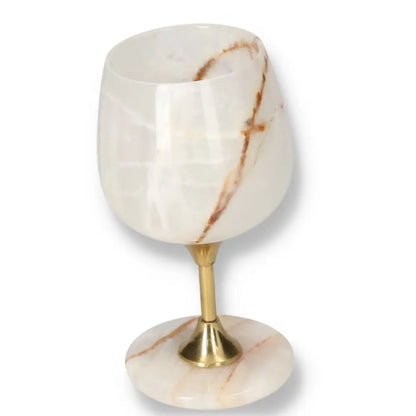 Exquisite onyx wine glass with unique veining, polished surface, and gold stem, exemplifying elegance and natural allure.