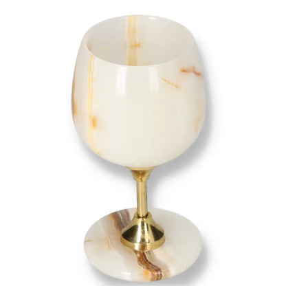 Exquisite off-white onyx wine glass with unique veining and polished surface, featuring a gold stem, perfect for sophisticated occasions.