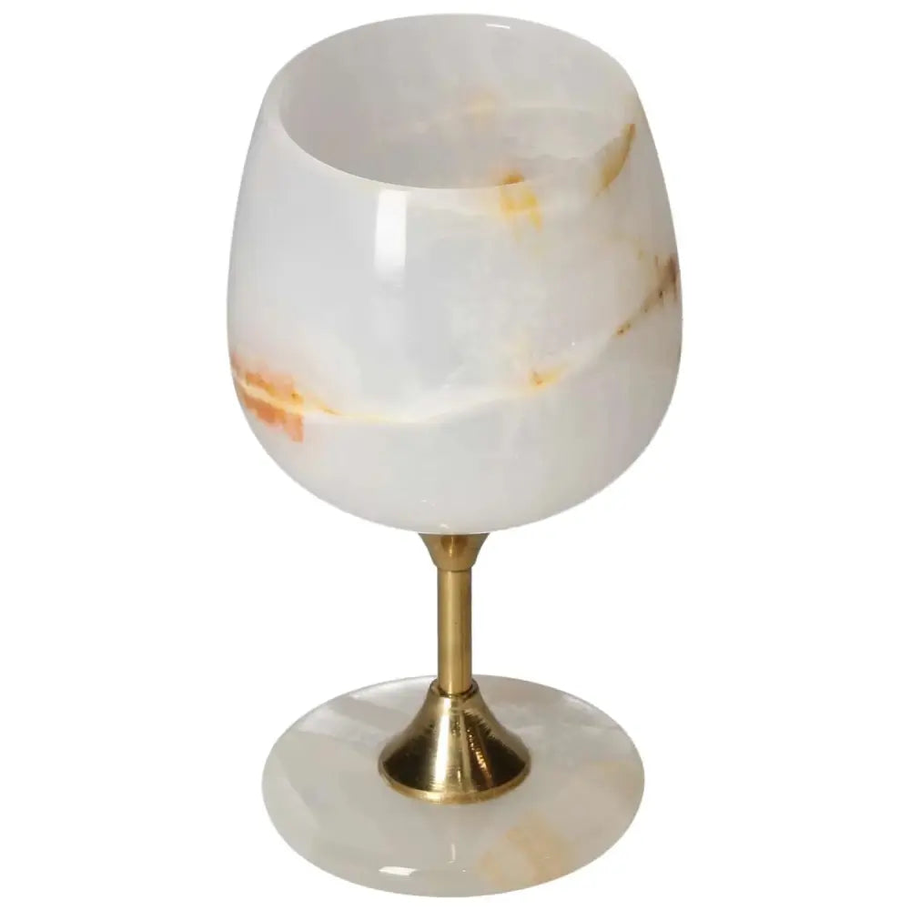 Elegant onyx wine glass with golden stem, featuring unique off-white and amber veining. Perfect for sophisticated dining.