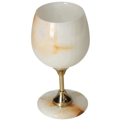 Elegant off-white onyx wine glass with unique veining, polished surface, and gold stem, perfect for sophisticated occasions.