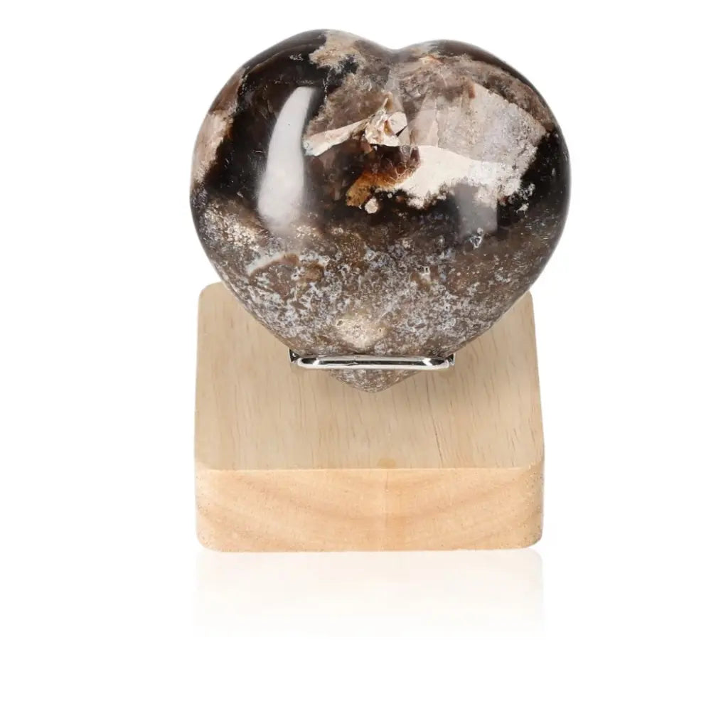 Heart-shaped Opal Verte crystal on wooden stand. Enhances cosmic consciousness, stimulates love, and reignites passion. Stand not included.