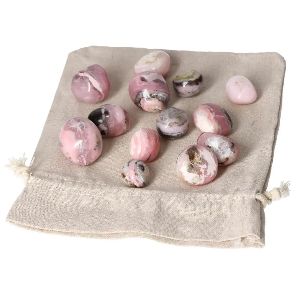 Pink Opal Tumbled Stones on Beige Cloth, Showcasing Soft Pastel Hues and Opalescent Sheen for Emotional Healing
